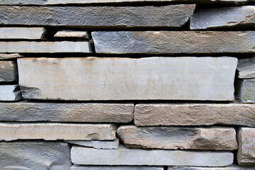 Light brown and grey stone wall with empty space in between. Beautiful stone pattern, background. Wallpaper