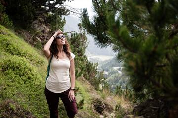 Female hiker enjoying mountain view in a lush green forest