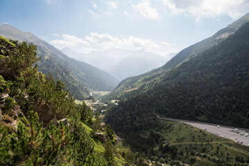 Obraz premium Panoramic view of a mountainous landscape with a winding road and dense forests