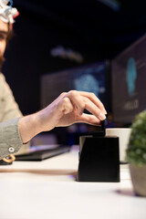 Programmer inserting cartridge into PC to use high tech program allowing for brain transfer into cyberspace. Close up shot of developer putting disk in computer to start consciousness upload