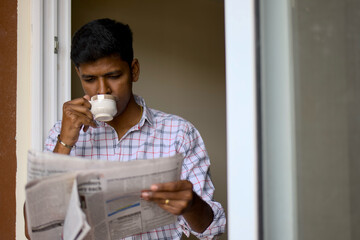 Man enjoying his morning coffee while reading the newspaper at home during a quiet morning
