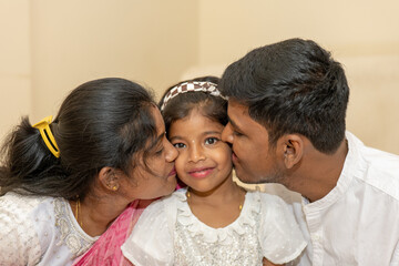 Parents kissing their childs chin