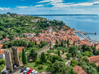 Aerial view of Piran medieval old town in Istria Slovenia with red rooftops, city wall, catholic...