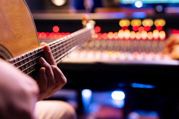 Skilled artist performing electro acoustic guitar sounds to create a new hit, making music in...