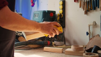 Manufacturer working in joinery using sanding block to remove imperfections on wood piece. Woodworking specialist using coarse grade sandpaper to do manual sanding on lumber, camera B close up