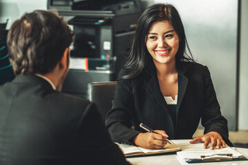 Businesswoman from human resources department is interviewing businessman candidate for job application in meeting room while considering his CV resume document. Employee hiring business concept. uds