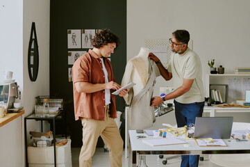 Biracial tailor and designer working on new female collection together in famous atelier