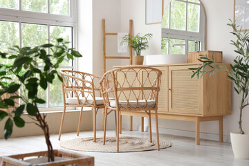 Wooden chest of drawers with sink, mirror and wicker chairs in bathroom