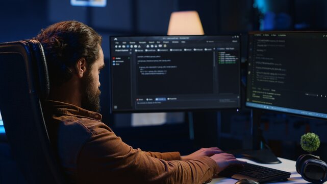 Computer scientist developing code on PC while in apartment office using java programming languages. IT admin brainstorming ways of fixing database errors while working from home, camera A