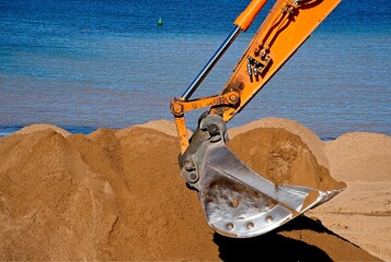 Digger moving sand at the beach