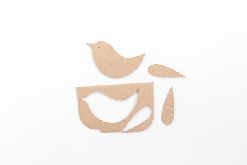 a paper birds sitting on top of a table, cut out of cardboard, 
