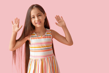 Happy little girl smiling on pink background