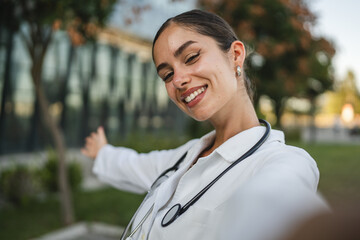 Young woman medical doctor portrait happy smile in front of hospital