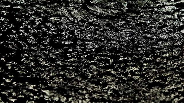 Tokyo, Japan -August 27, 2024: Heavy rain falling on a pool on asphalt pavement at night