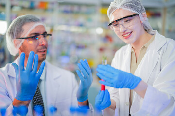 scientists perform experiments and record data. people arranges equipment with test tubes and chemicals for producing medicine and biochemistry. man hold tubes of chemical liquids and plant samples.