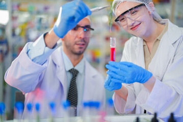 scientists perform experiments and record data. people arranges equipment with test tubes and chemicals for producing medicine and biochemistry. man hold tubes of chemical liquids and plant samples.