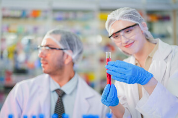 scientists perform experiments and record data. people arranges equipment with test tubes and chemicals for producing medicine and biochemistry. man hold tubes of chemical liquids and plant samples.