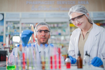 scientists perform experiments and record data. people arranges equipment with test tubes and chemicals for producing medicine and biochemistry. man hold tubes of chemical liquids and plant samples.