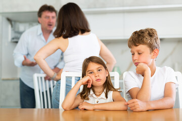 Children are sitting at kitchen table and hear their parents swearing, talking about divorce....