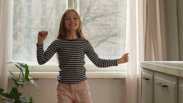 Happy little Caucasian girl dancing in room home vacation child daughter offspring student schoolgirl preteen age pastime fun childhood learner pupil innocence dance music rhythmic movement kid female