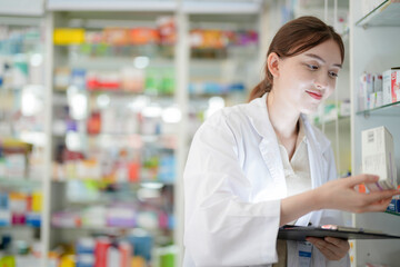 woman pharmacist wearing lab coat carefully selects medication in a pharmacy. critical role of pharmacists in ensuring patient safety and effective healthcare. female organizes medication on shelves.