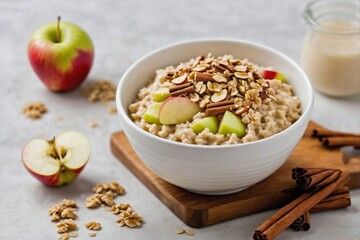 Fototapeta premium Apple Cinnamon Oatmeal: Top-down view of a simple white bowl filled with creamy oatmeal and fresh apple chunks