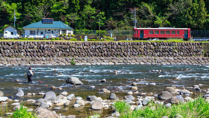 釣り人にならってケモノ道をたどり岩だらけの川原へ降りると長良川鉄道の気動車がやって来た