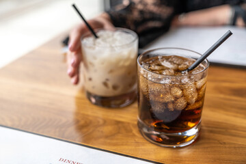 Cocktail drinks on table with a woman’s hand. Romantic dinner at restaurant