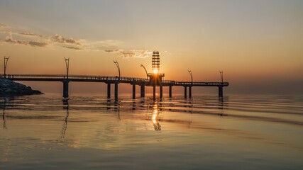 The sun beams through the tower of Brant Street Pier, as it rises over the lake during the morning at Burlington, Ontario, Canada