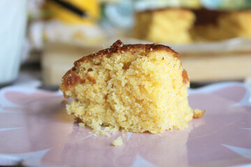 Fresh Baked Homemade Yellow Honey Cornbread Sliced on Parchment Paper with a Serving on a Plate and Milk