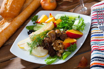 Dietary salad with chicken hearts, slices of peach, pear and roasted cheese