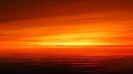 Obraz premium A fiery orange sunset over a calm body of water.