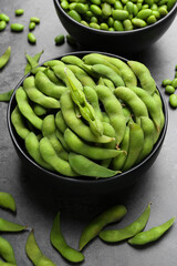 Raw green edamame soybeans and pods on grey table