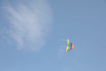 One colorful kite flying in blue sky. Space for text