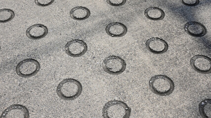 丸いリング状のくぼみがつけられたコンクリートの地面