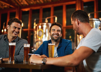 Men, smile and relax with beer at pub for social gathering, communication and bonding on weekend. Friends, discussion and conversation with alcohol beverage for happy hour, drinks or reunion together