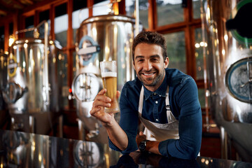 Portrait, beer and man brewer in distillery for taste of alcohol for quality control production. Happy, career and business owner with drink for fermentation in factory for oktoberfest in Munich.