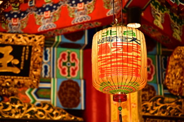 Taiwan - Jan 17, 2024: Close-up of a lantern inside Taipei Bao An Temple, with a grand interior showcasing intricate woodwork and ornate roof details.