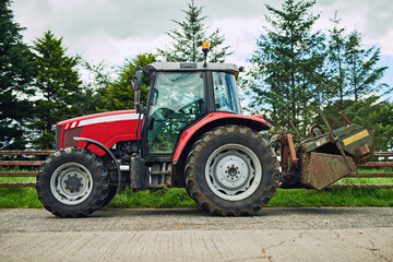 Outdoor, countryside and agriculture with tractor for driving, tiling and cultivation of soil for crop growth. Blue sky, nature and machine truck on farm for harvesting, planting and sowing of seeds