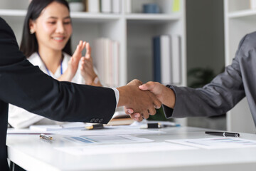 Businessmen Shaking Hands in Agreement at Modern Office with Colleague Applauding in Background
