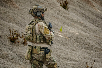 A group of military men in combat gear patrol in the middle of a desert and tropical jungle....