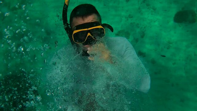 Man goes swimming with mask from yacht, man falls backwards into water while traveling on yacht