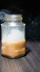 milk coffee glass isolated on wooden table, releasing smooth asphalt on black background for copy space.