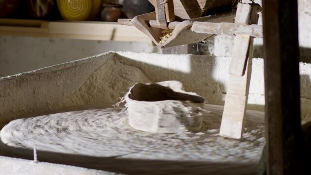 The ancient old stone grain mill grinding wheat or grains into flour using millstone