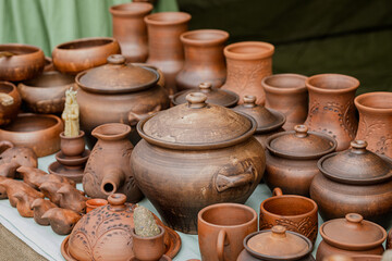 Rows of traditional ethnic pottery in the assortment at the fair outdoor, close-up, selective focus.