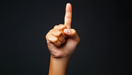 A hand with an extended index finger pointing upwards on a dark background, symbolizing attention or a call to action.