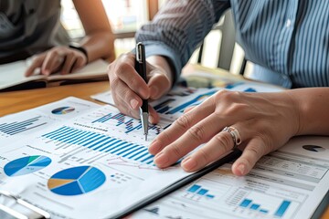 Person Analyzing Financial Data with Pen and Charts
