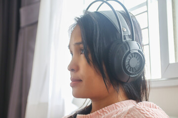 Asian Woman wearing headphones to listening music