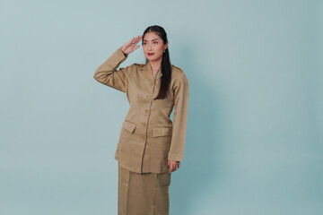 Confident Indonesian government worker wearing a khaki uniform doing salute pose.
