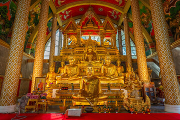 Fototapeta premium The gold Buddha statue inside the beautiful church of Wat Phra That Nong Bua and Wat Phra That Nong Bua is an important, attractive, and renowned temple of Ubon Ratchathani, Thailand